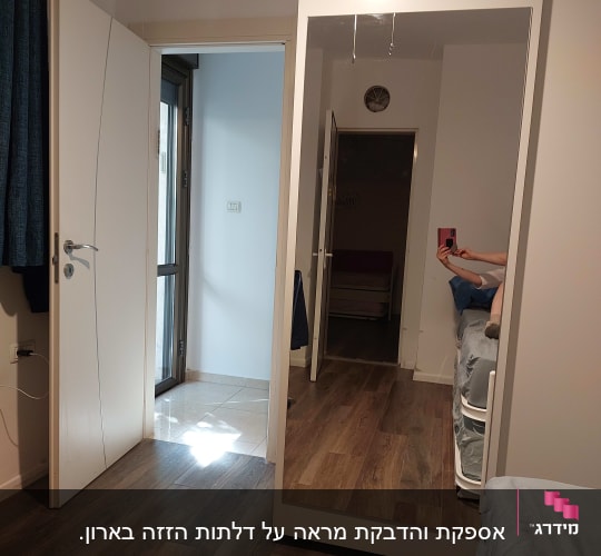 מראה גדולה בחדר עם רצפת עץ